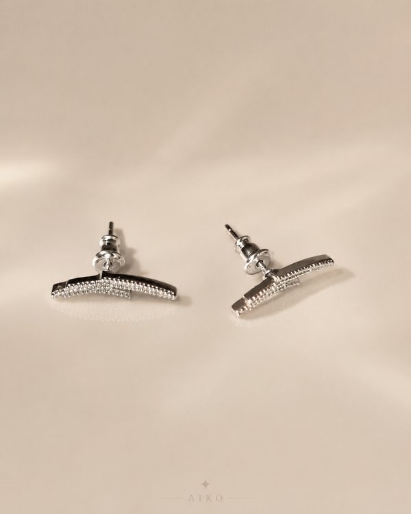 Aretes plateados curvos con brillos