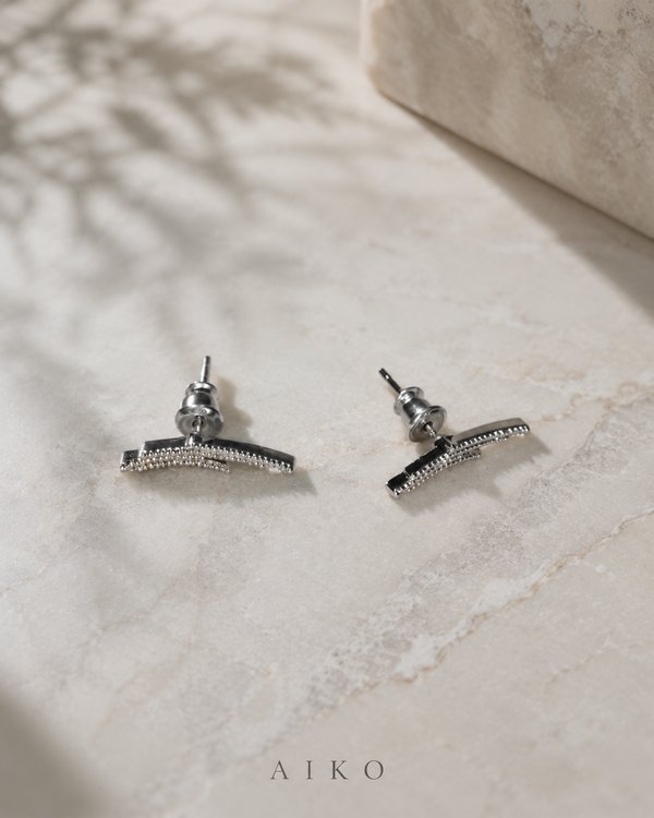 Aretes plateados curvos con brillos