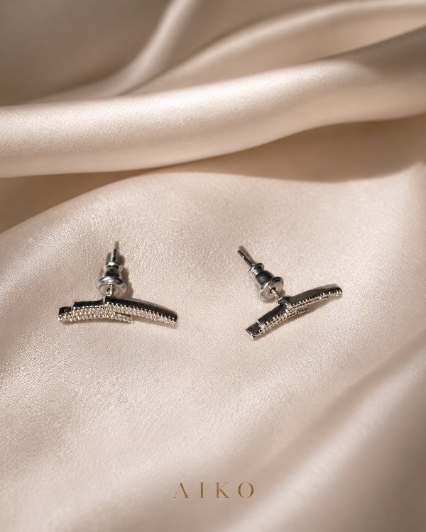 Aretes plateados curvos con brillos