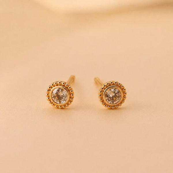 Aretes dorados circulares con centro oscuro