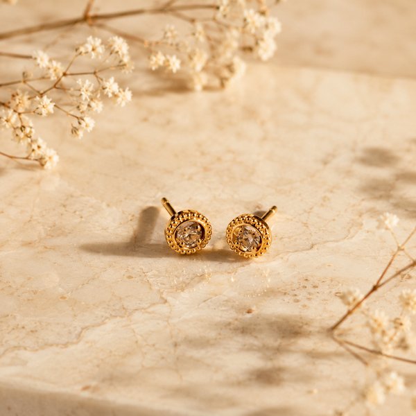Aretes dorados circulares con centro oscuro