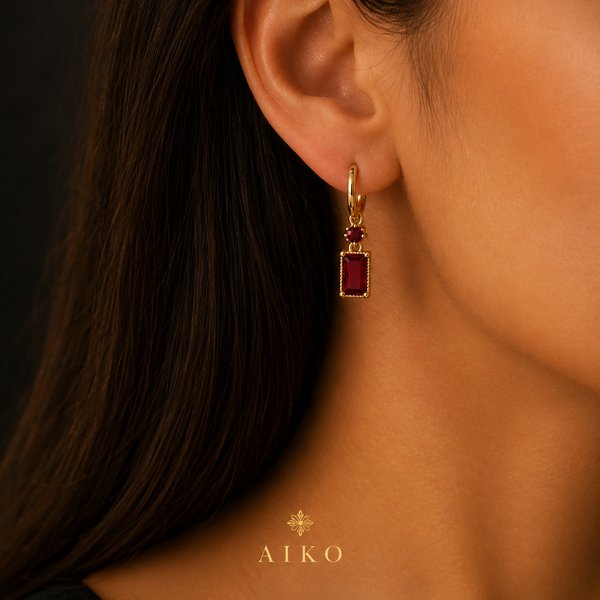 Aretes dorados con piedra roja rectangular