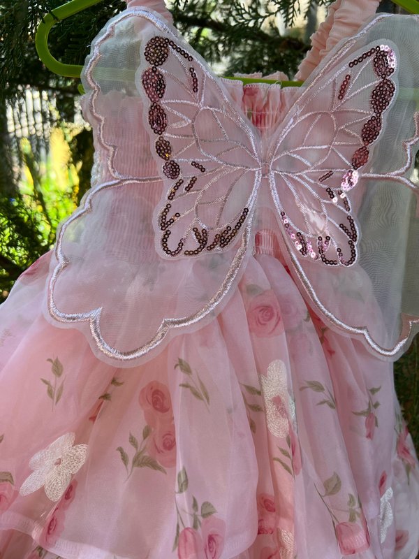 Vestido en tono rosa con detalles de flores y alas de mariposa 🦋
