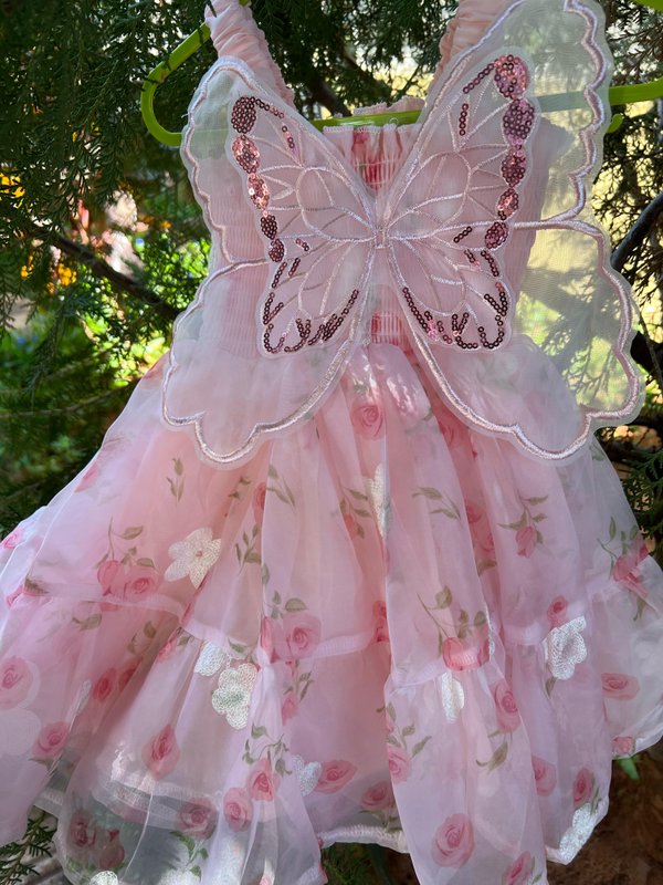 Vestido en tono rosa con detalles de flores y alas de mariposa 🦋