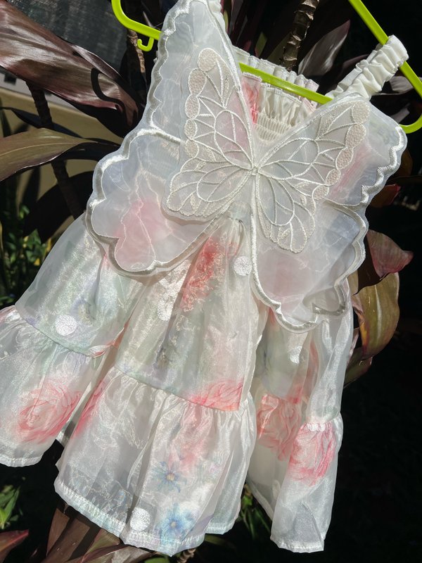 Vestido en tono blanco con diseños de flores y alas de mariposa 🦋