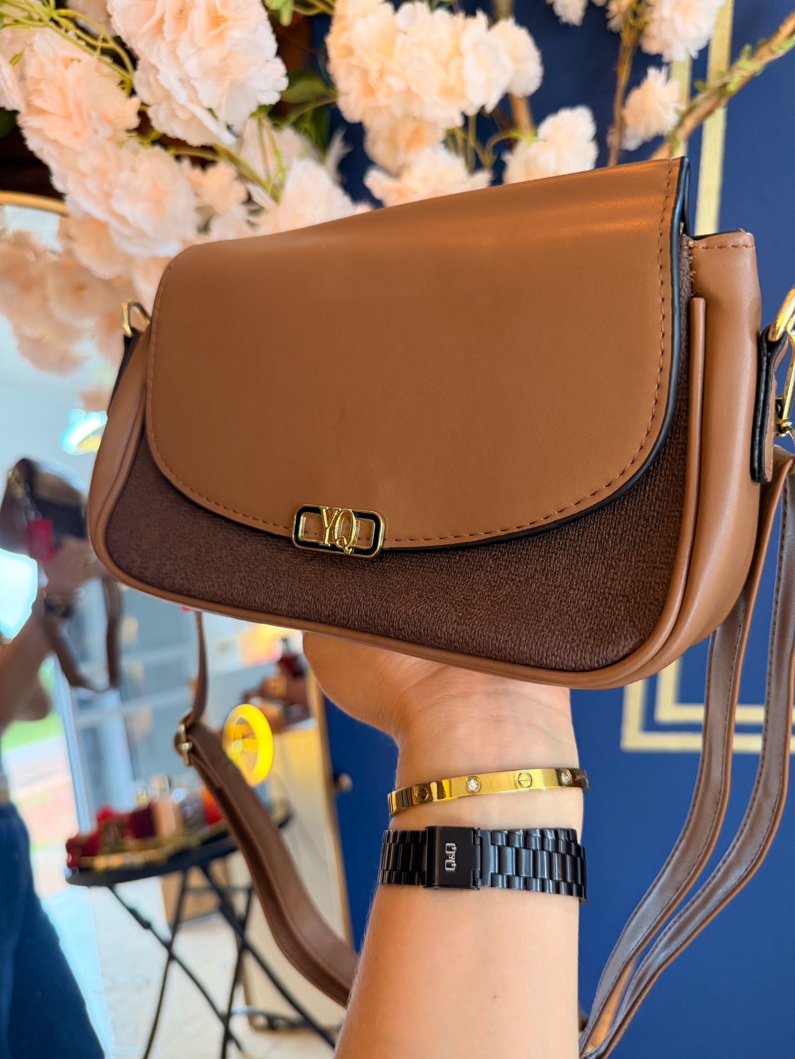 Cartera marrón con solapa y cierre metálico