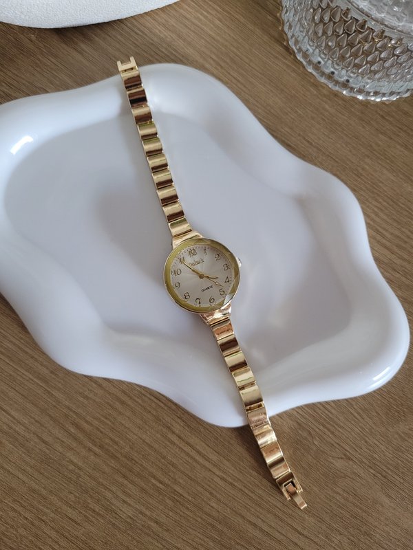 Reloj dorado con esfera redonda