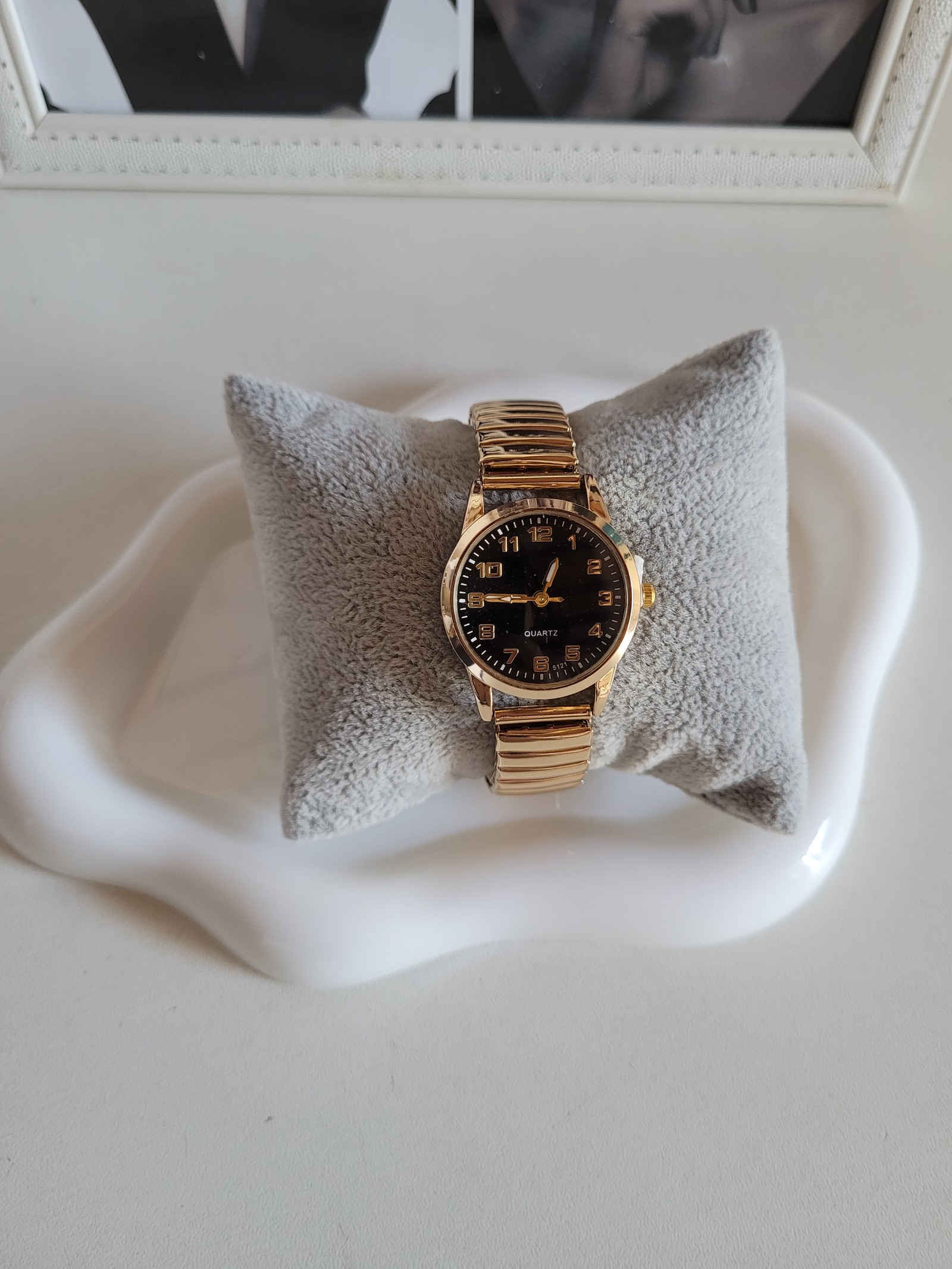 Reloj dorado con esfera negra y números arábigos