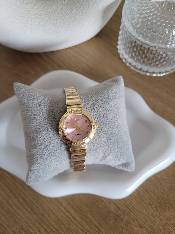 Reloj dorado con esfera rosada