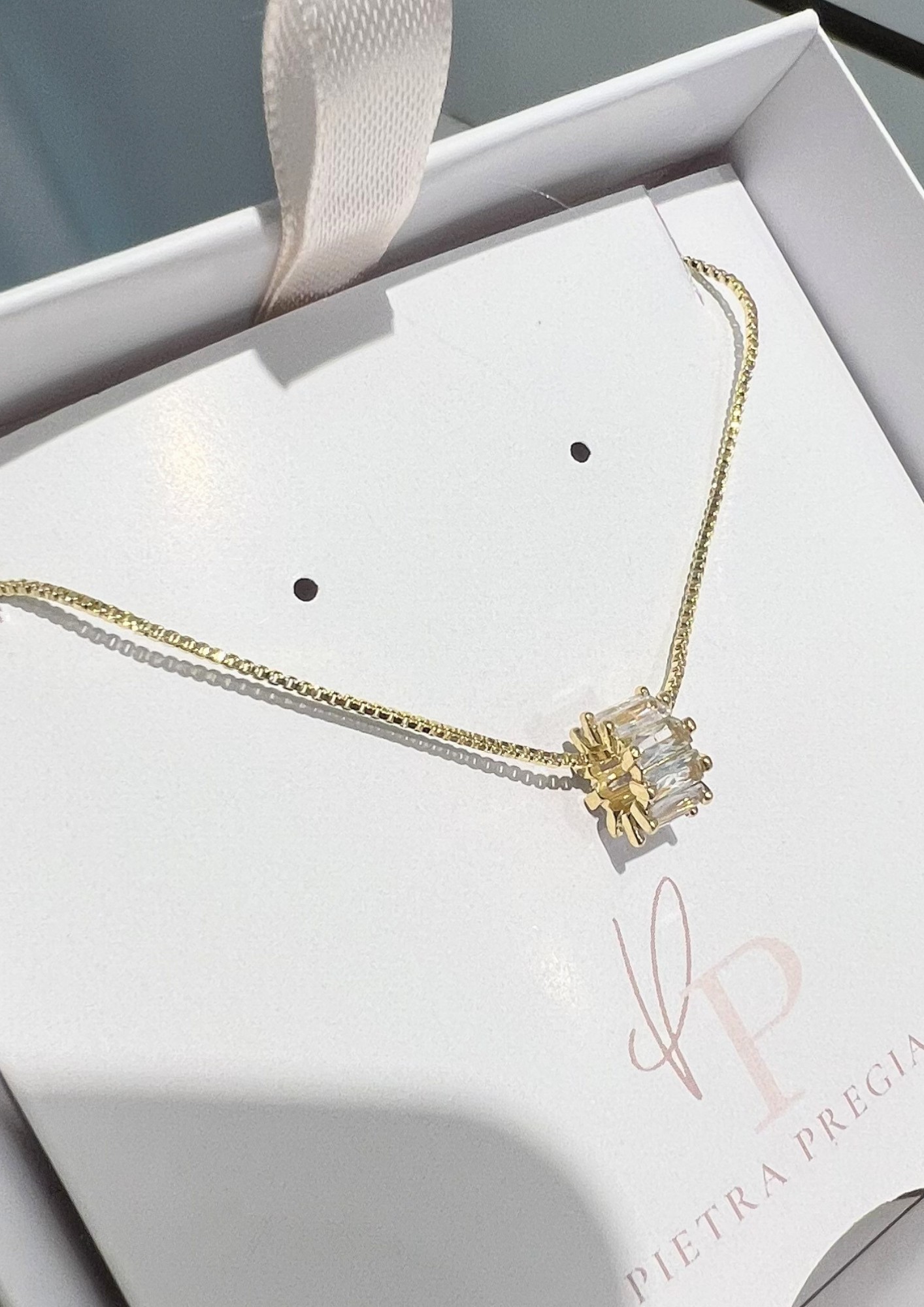 Cadena dorada con dije de piedra transparente