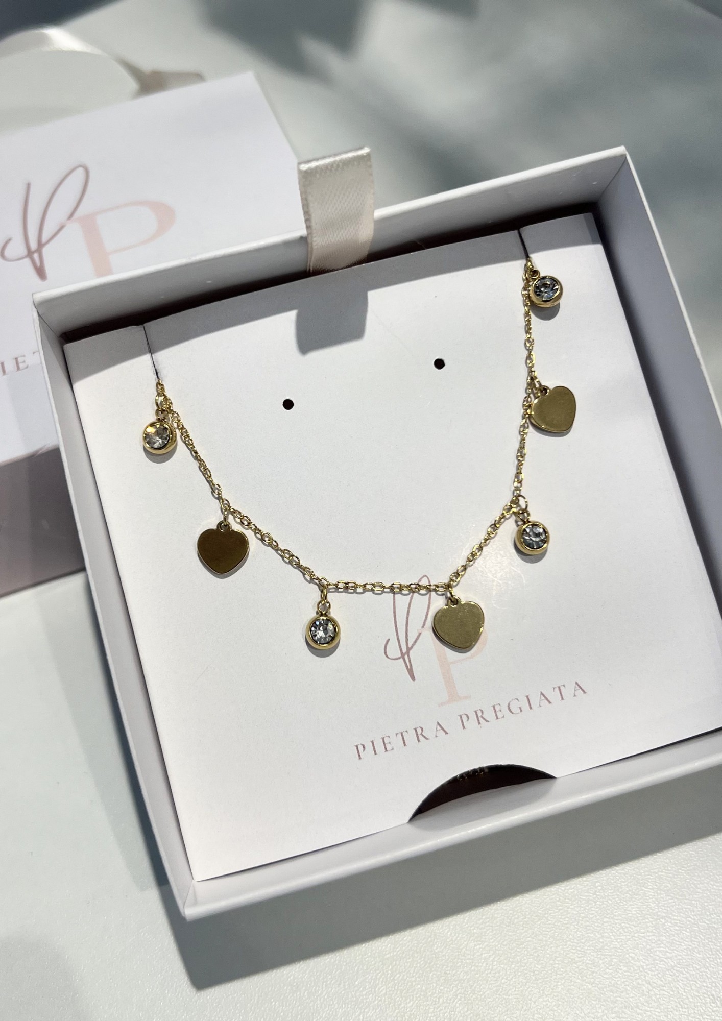 Cadena dorada con dijes de corazones y piedras