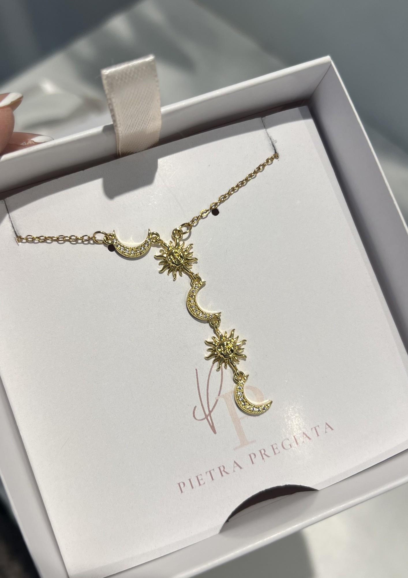Cadena dorada con dijes de lunas y soles