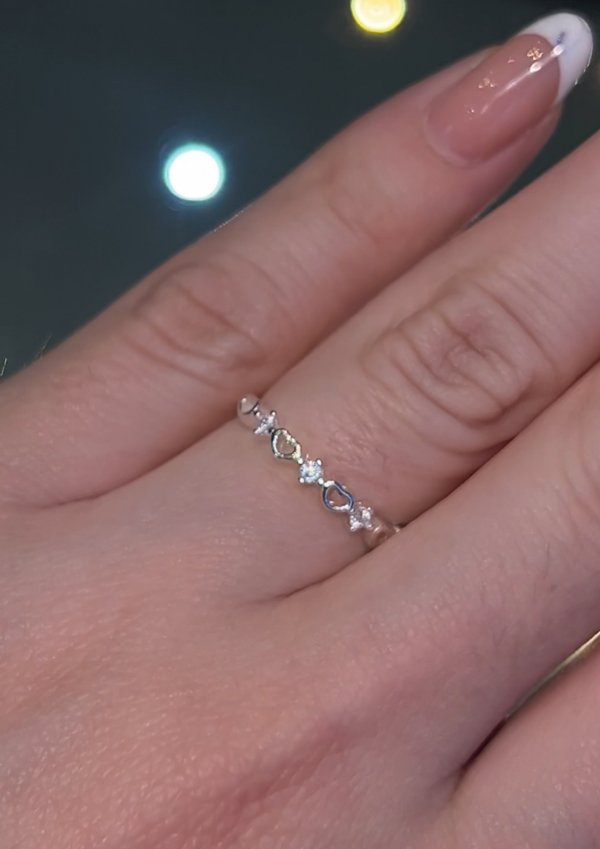 Anillo plateado con corazones y detalles brillantes