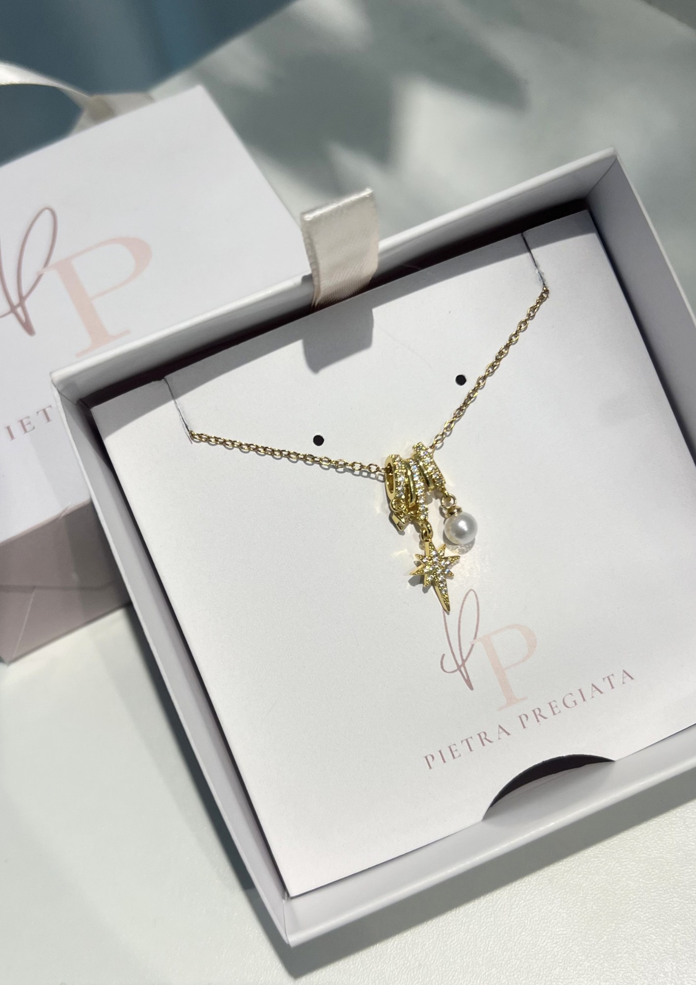 Cadena dorada con dije de estrella y perla